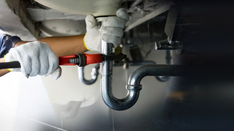 Plumber working under a kitchen sink