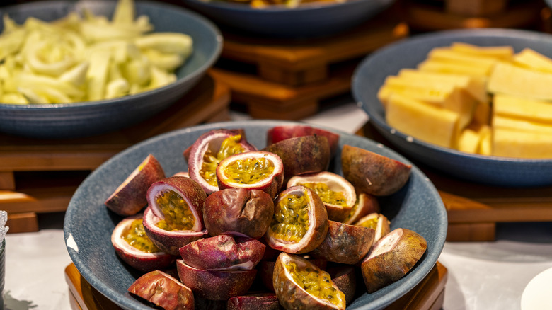 Halved passionfruit in blue bowl