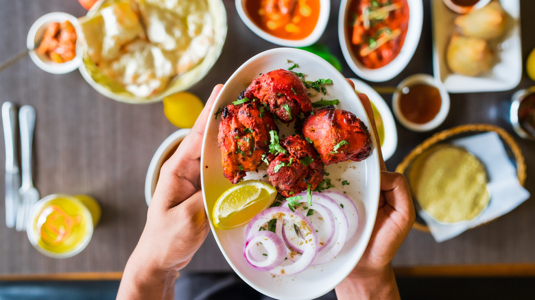 Platter of tandoori chicken and Indian side dishes