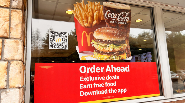 A McDonald's store has a promotion in the window for ordering ahead on the app