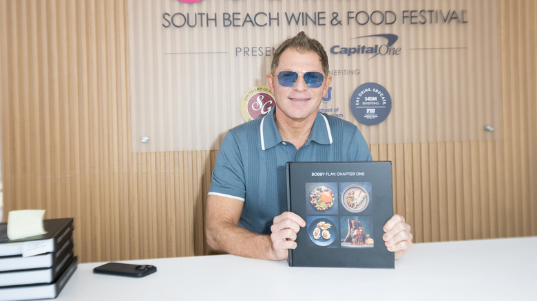 Bobby Flay pictured with a cookbook