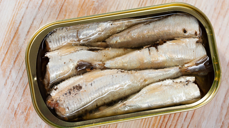 canned sardines pictured on cutting board