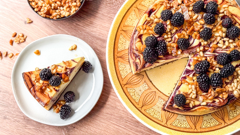 Blackberry and pine nut cheesecake on serving platter and plate