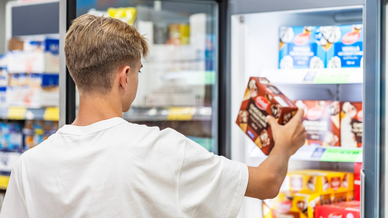 a boy grabbing food from the frozen section