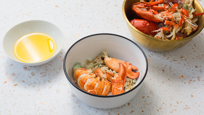 Bowl with clarified butter, bowl with lobster meat and bowl with shells