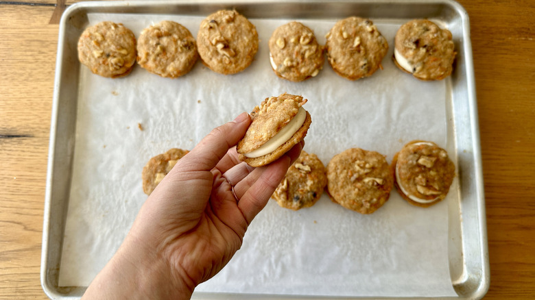 Hand holding carrot cake cookie sandwich