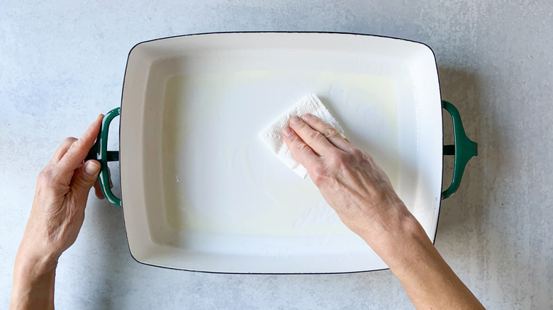Rubbing inside of baking pan with oil