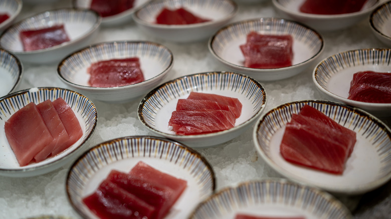 Slices of tuna served on multiple plates, placed on ice to maintain freshness