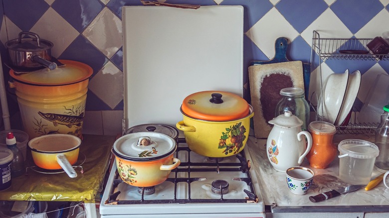 Cluttered kitchen with pots and pans on countertop