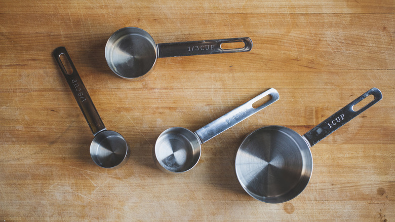 measuring cups on wood cutting board