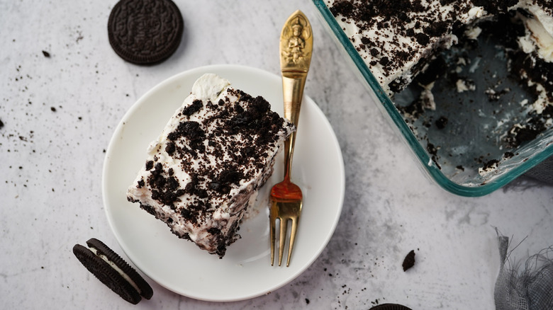 An icebox cake has been made by layering cookies and whipped cream, sliced, and served on a plate.